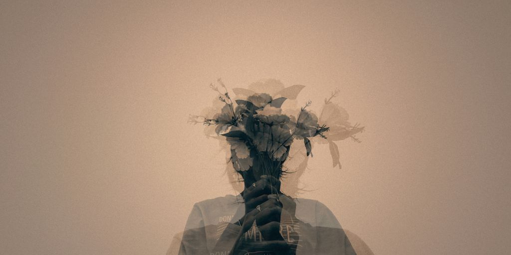 gray scale photo of man holding flower