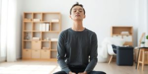Person meditating, focused gaze, calm expression.