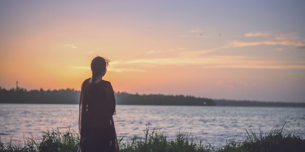 silhouette photography of woman looking at body of water